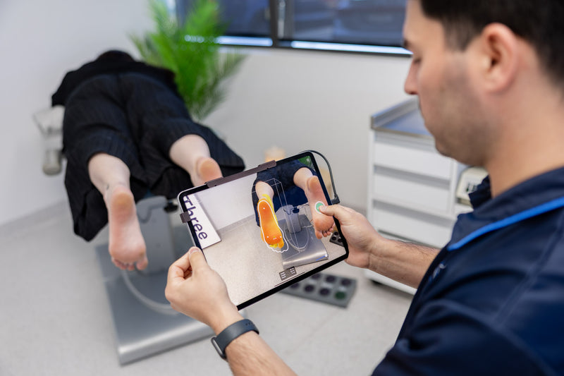 A clinician capturing a digital scan of a patient’s foot