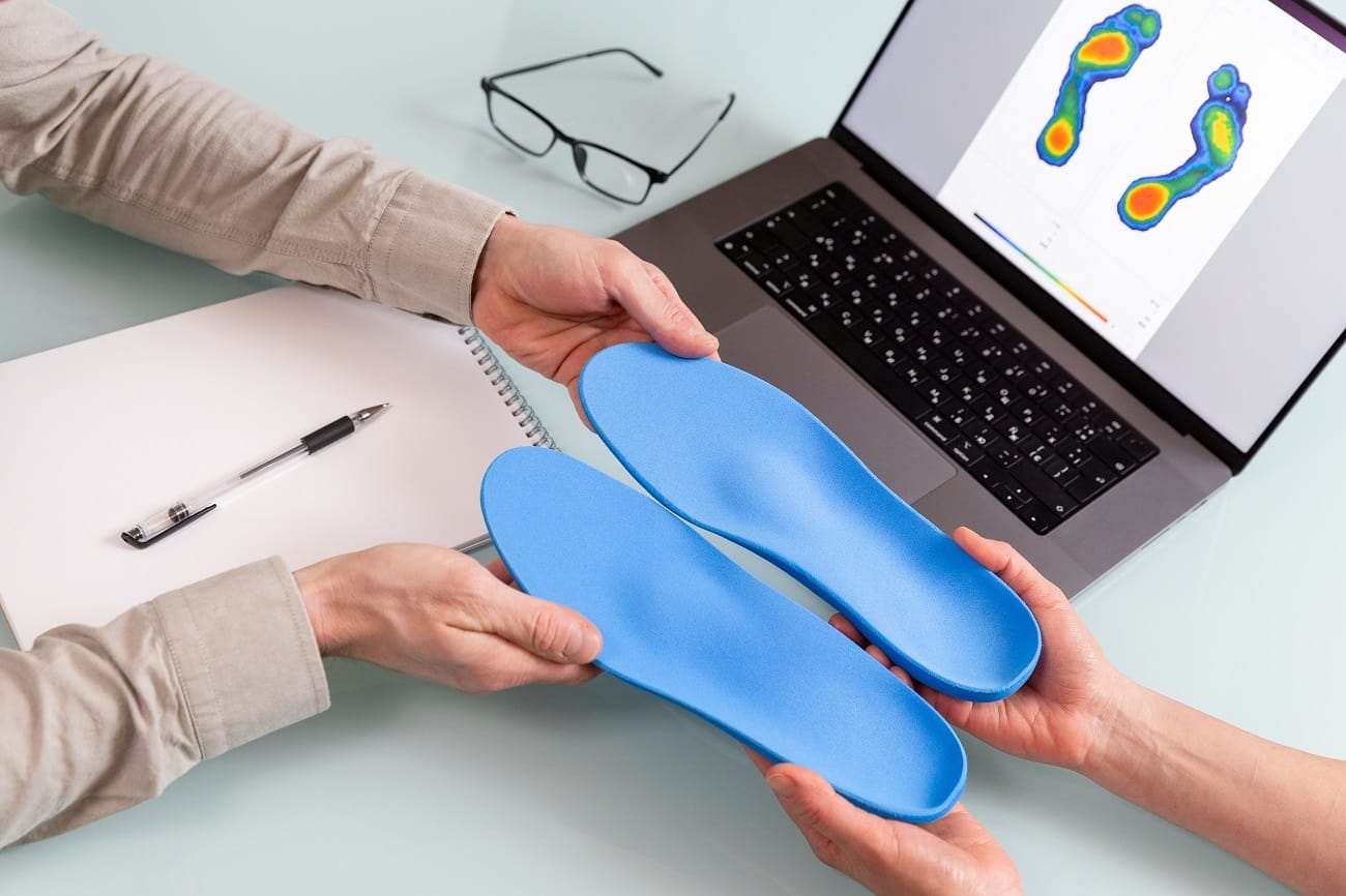 A clinician comparing custom orthotics with a digital gait pressure map
